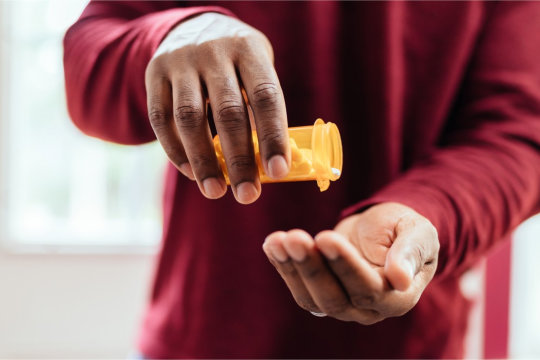 image of adult guy holding his medications